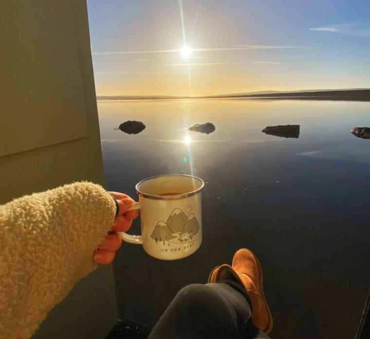 Sunrise with a cup of tea in a campervan