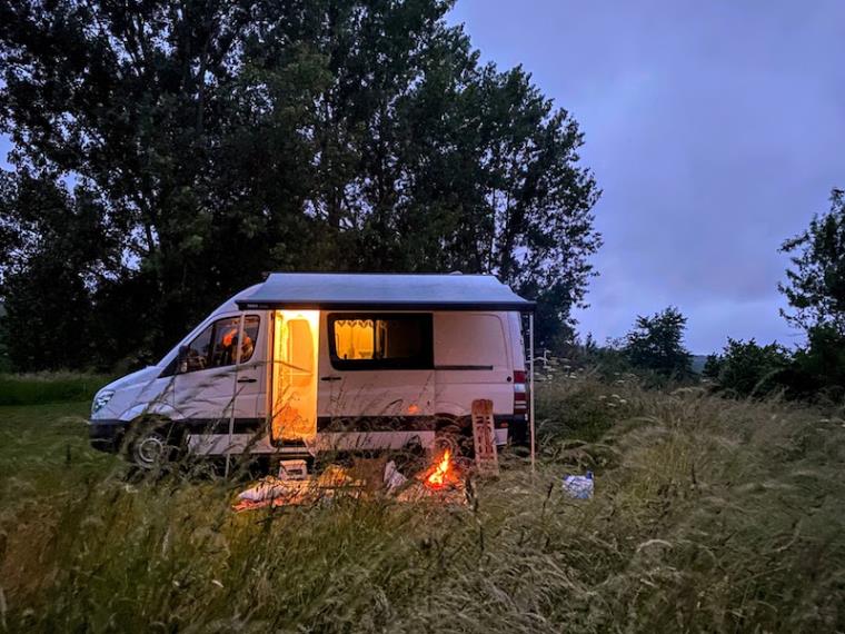 Campervan in field at dusk with extended awning