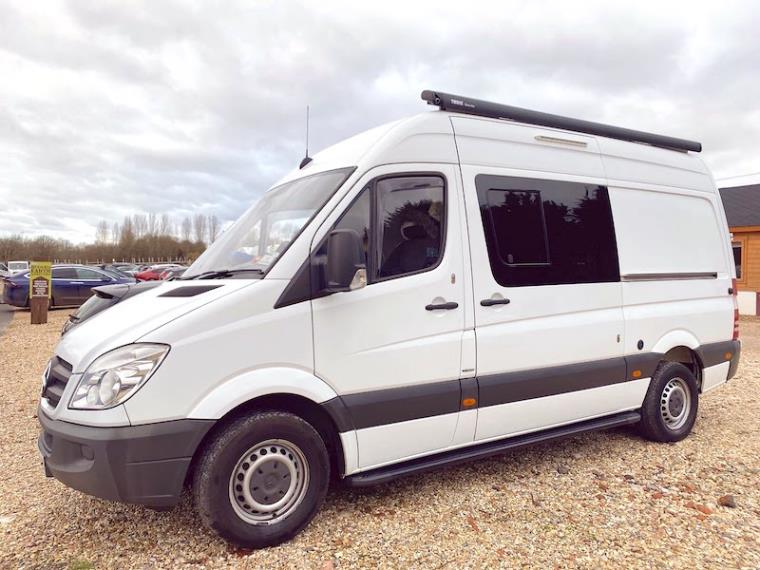 White Mercedes Benz Sprinter campervan in carpark