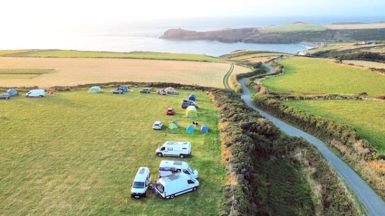 Drone shot of white campervans parked at Eco Caerhys Camping