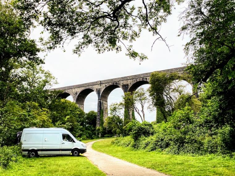 Mercedes Sprinter campervan parked next to viaduct