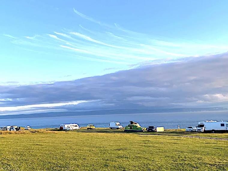 Campervans and motorhomes parked on Nash Point cliff edge at sunset